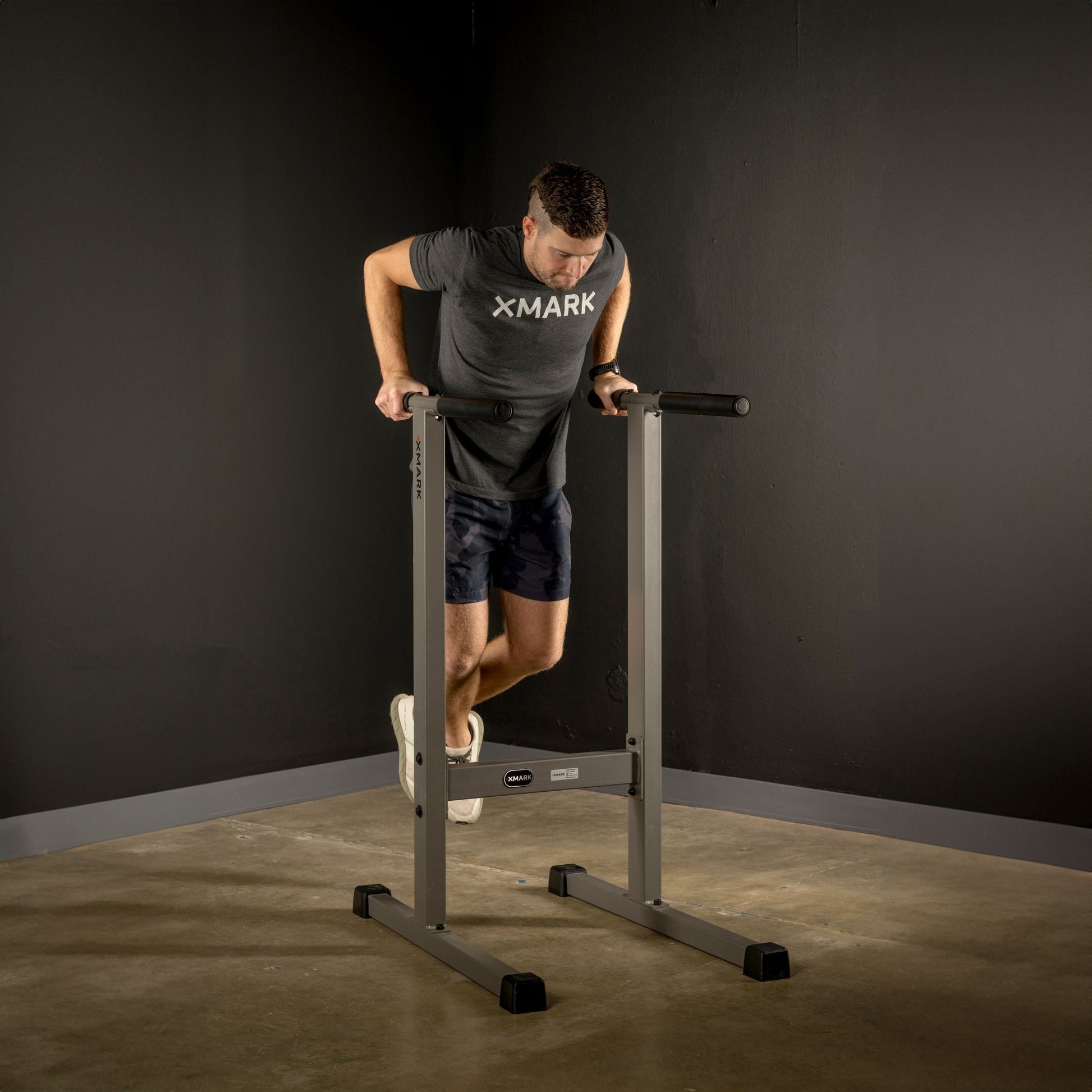 Man exercising on Dip Stand Station Bar for Vertical Knee Raise, demonstrating upper body strength training.