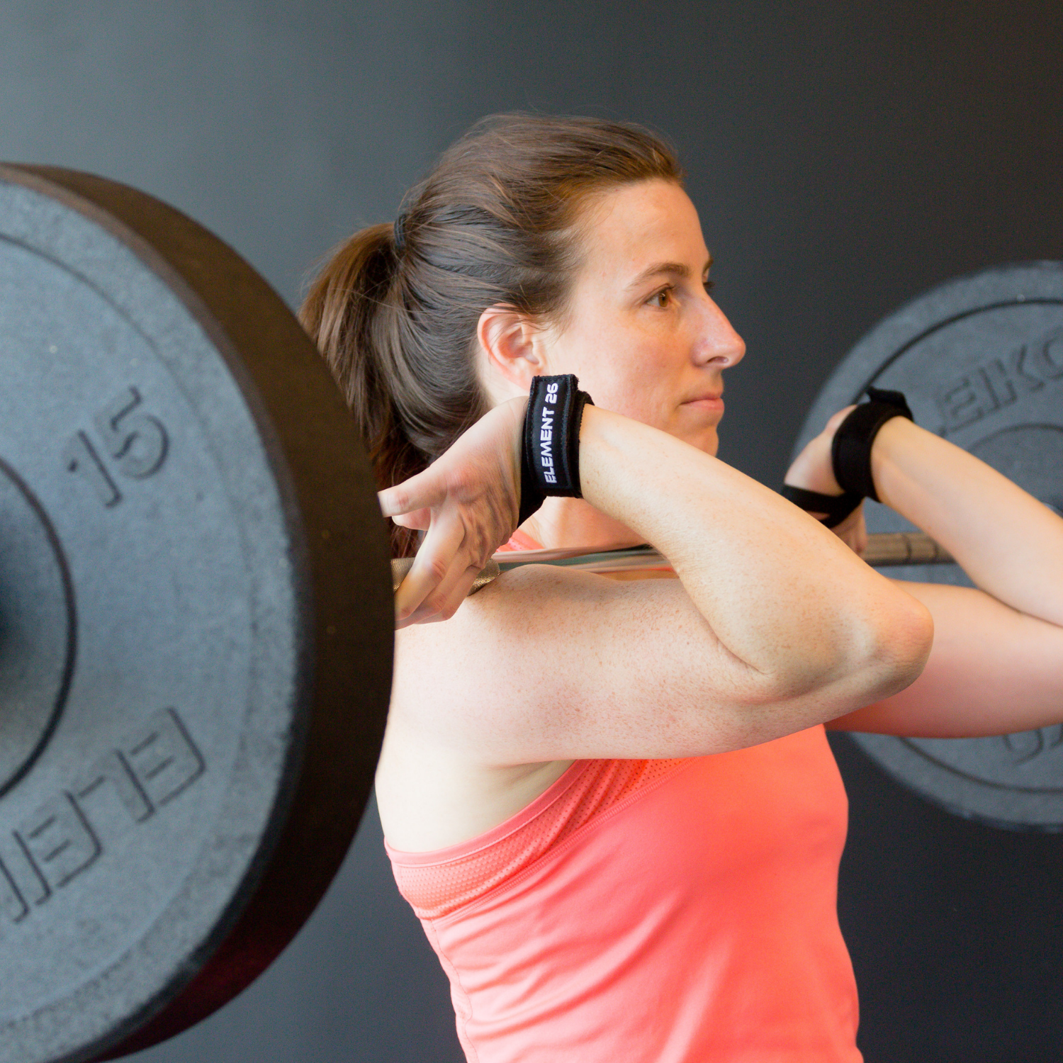 Athlete using Isowrap Wrist Wraps for weightlifting with a barbell, enhancing wrist support and performance.