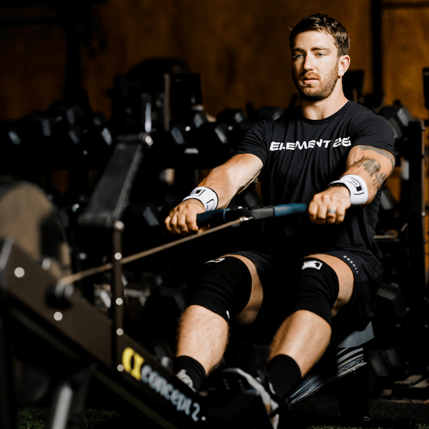 Man using rowing machine wearing 3mm Agility Knee Sleeves, showcasing breathability and flexibility during workout.