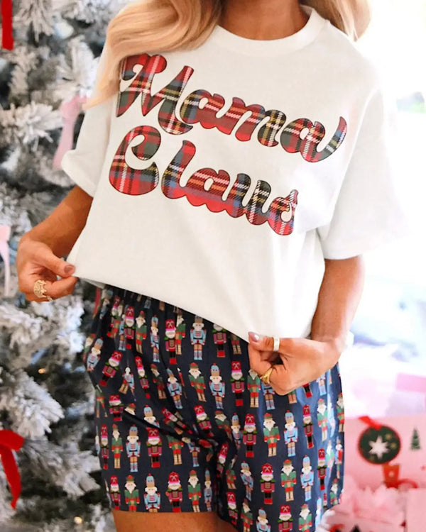 Mama Claus Plaid Letter Tee and Nutcracker Shorts 2pcs Lounge Set displayed by model in front of a Christmas tree.