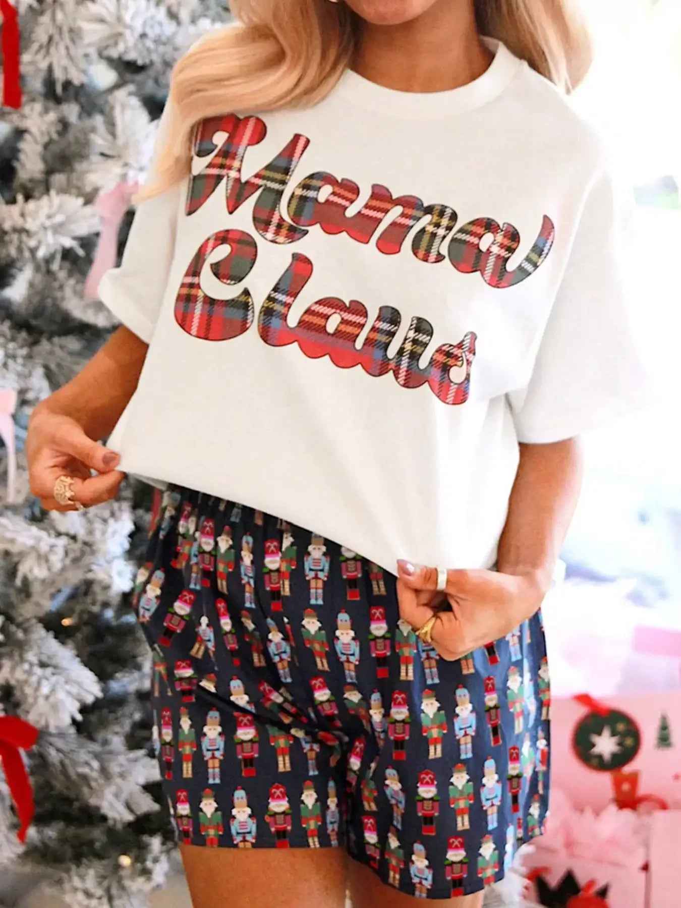 Mama Claus Plaid Letter Tee and Nutcracker Shorts 2pcs Lounge Set displayed by model in front of a Christmas tree.