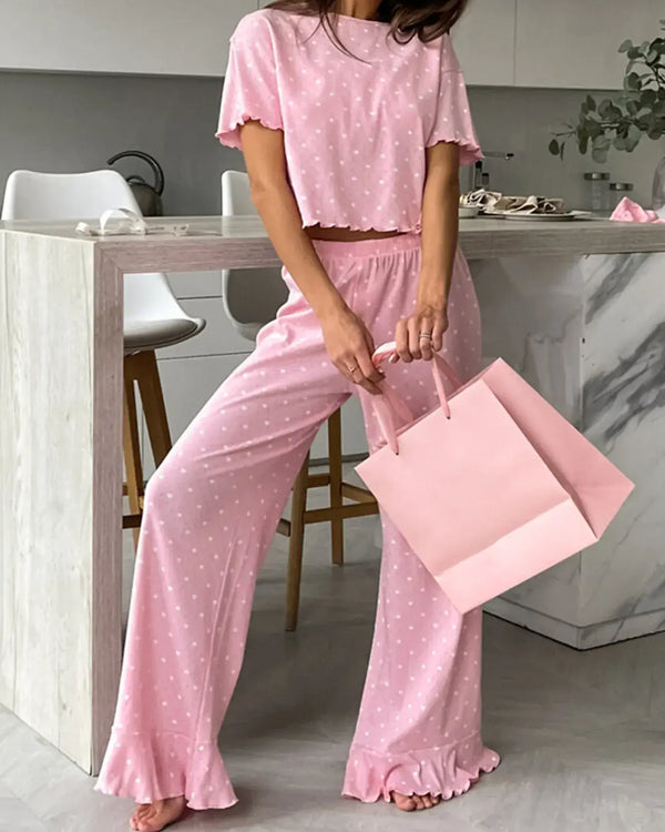 Polka Dot Round Neck Top and Pants Lounge Set worn by a woman holding a pink bag in a modern kitchen.