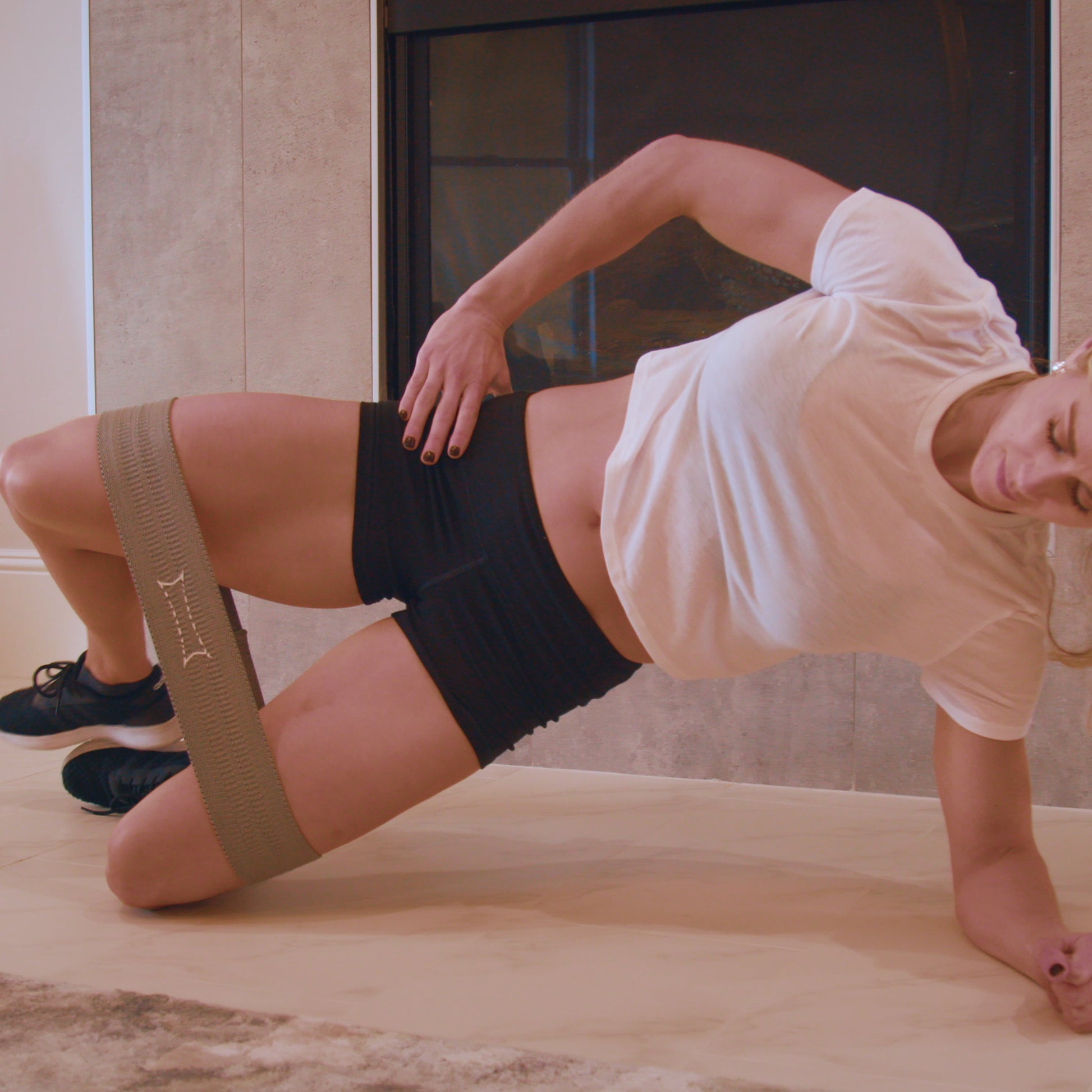 Woman exercising with Grippy Hip Circle Resistance Band, demonstrating lower body workout and stability.