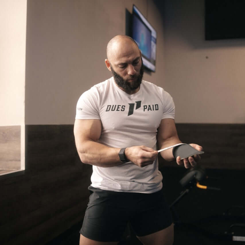 Isocomp Gymnastic Hand Grips being used by a man in a gym setting, showcasing durability and versatility.