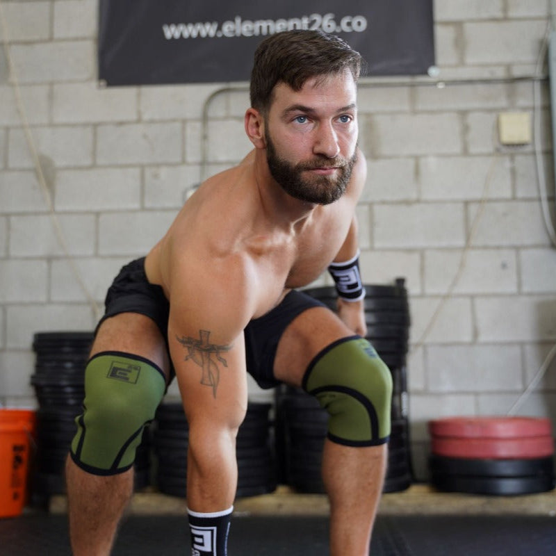 Man wearing 6mm Knee Sleeves while lifting weights in a gym setting.