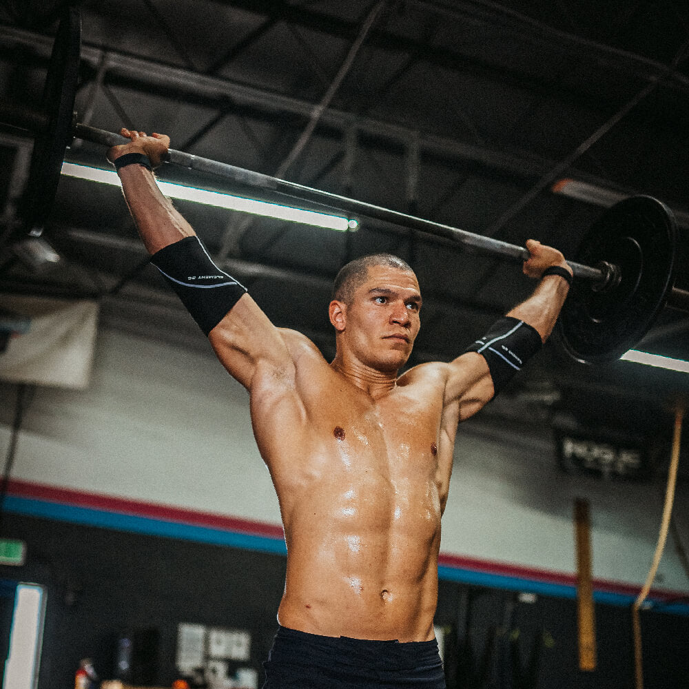 Athlete lifting weights with 5mm Elbow Sleeves for support and stability in strength training.