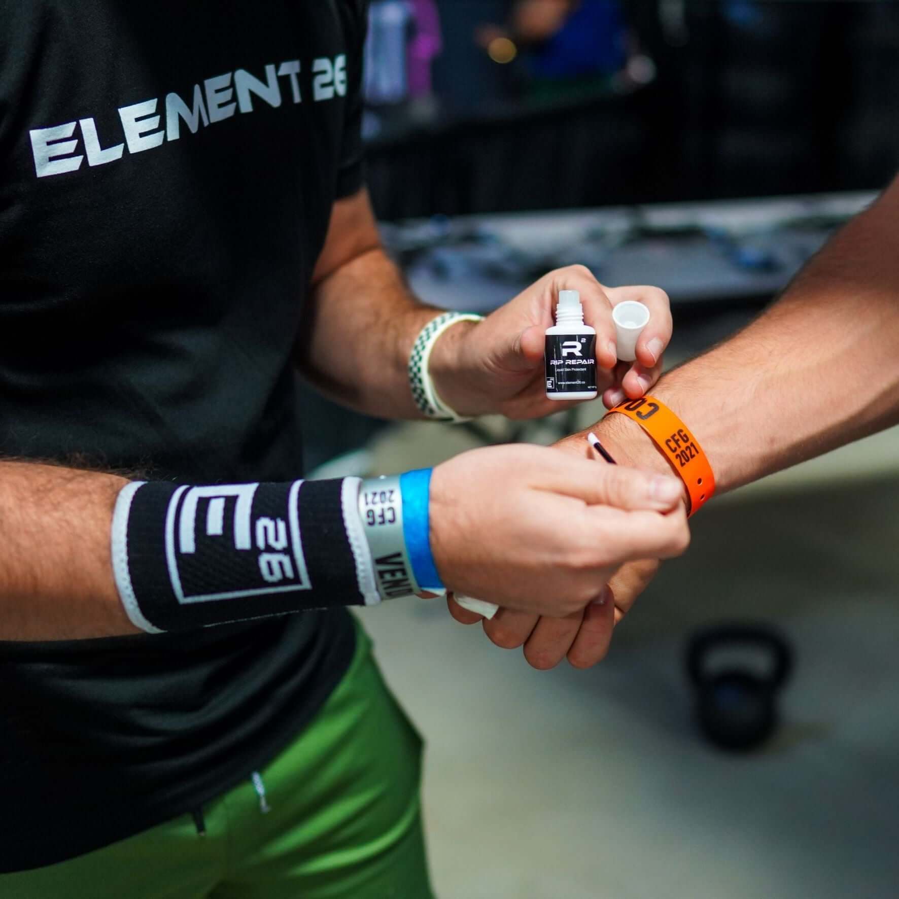 Two athletes applying Element 26 Rip Repair Skin Protectant during a training session.