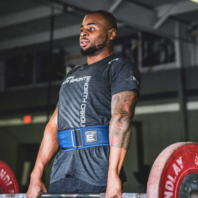 Man lifting weights while wearing a Self Locking Weightlifting Belt for optimal support and stability.