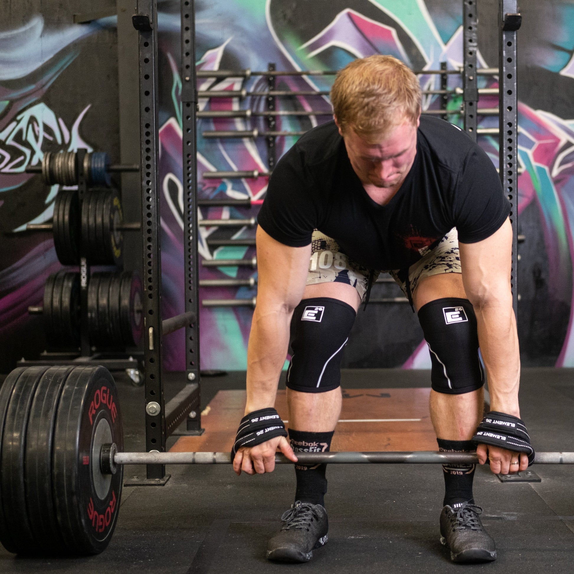 Athlete using padded figure 8 weightlifting straps for deadlift exercise in a gym setting
