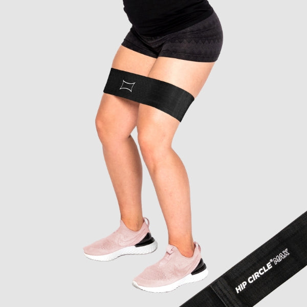 Woman exercising with the Hip Circle MAX around her thighs, designed for strength and hip muscle development.