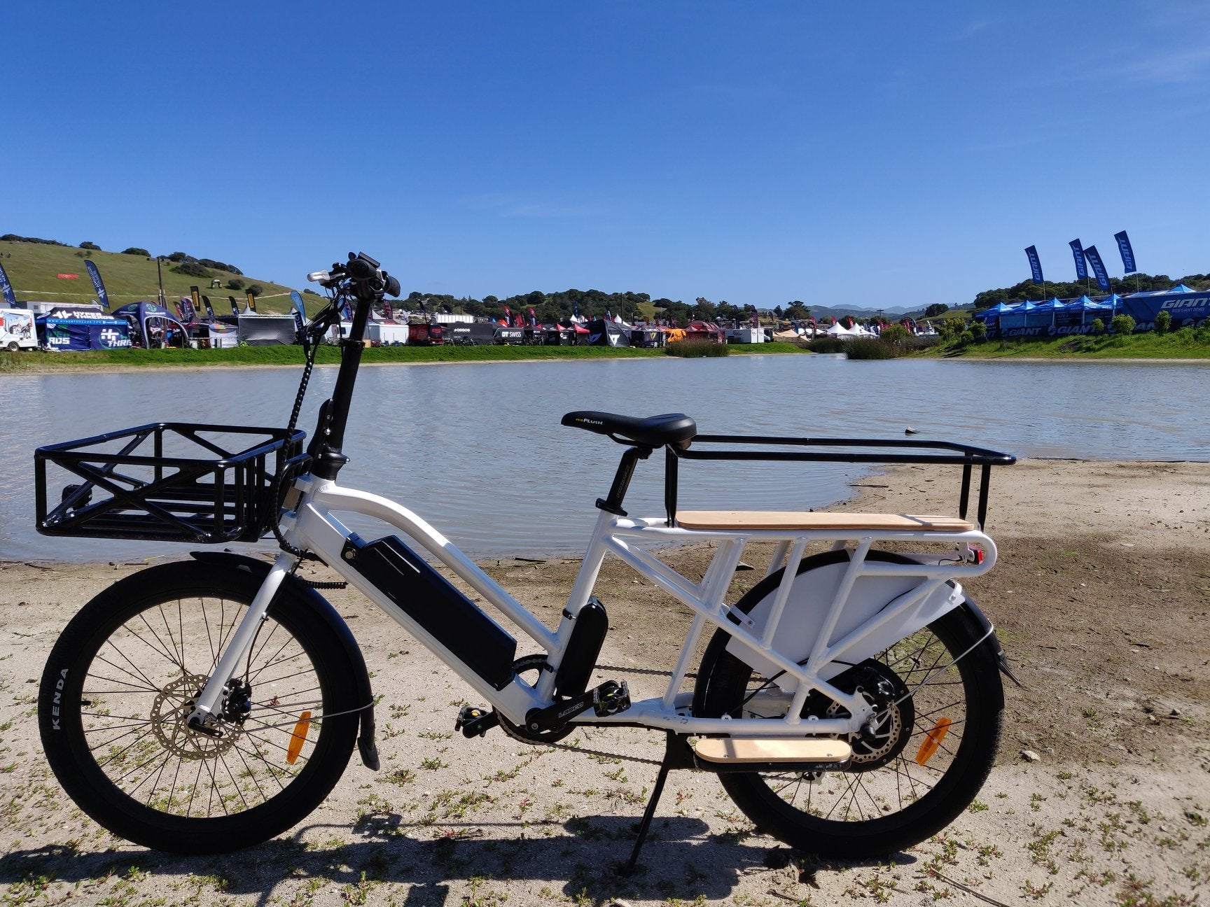 MAX-CARGO EBIKE parked by a lake, showcasing its design and features with a clear blue sky.