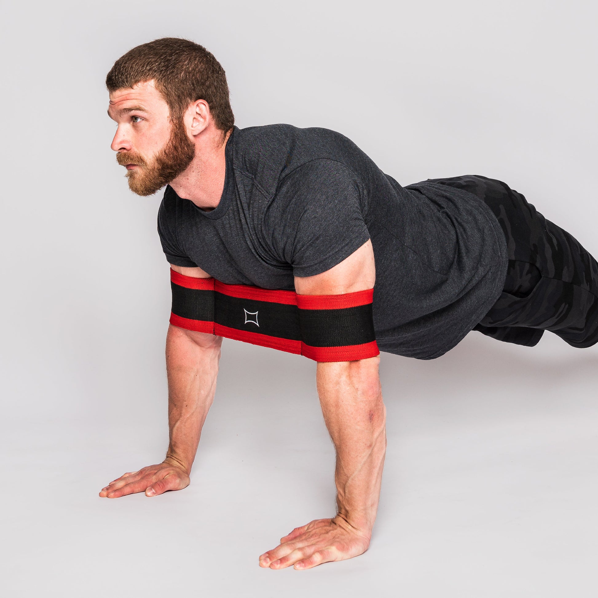 Man demonstrating the Sling Shot Push Up exercise with resistance bands for improved push-up performance.