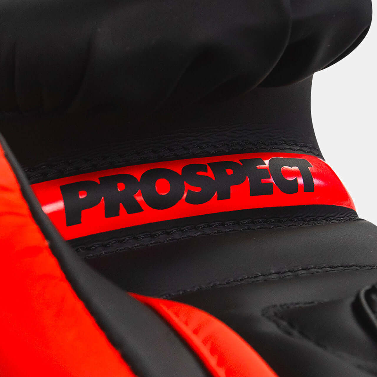 Prospect Kids Boxing Gloves by COMBAT CORNER close-up showing the logo on a black and red glove.