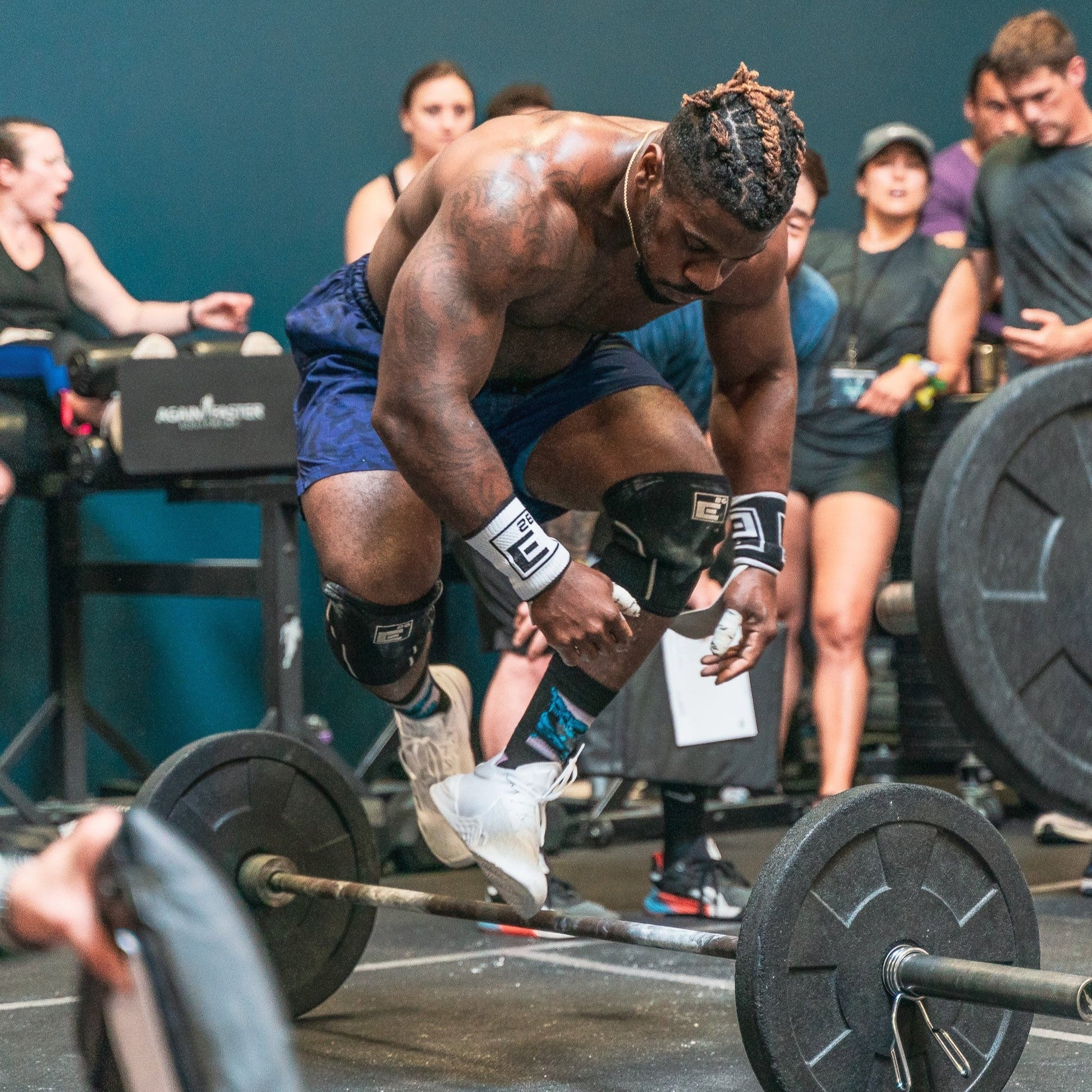 Athlete performing a lift during a workout while wearing wrist sweat bands for better grip.