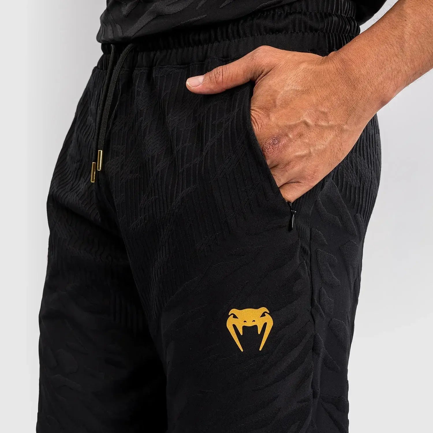UFC Fusion Authentic Fight Night Walkout Joggers featuring a sleek design and distinctive venom logo close-up.