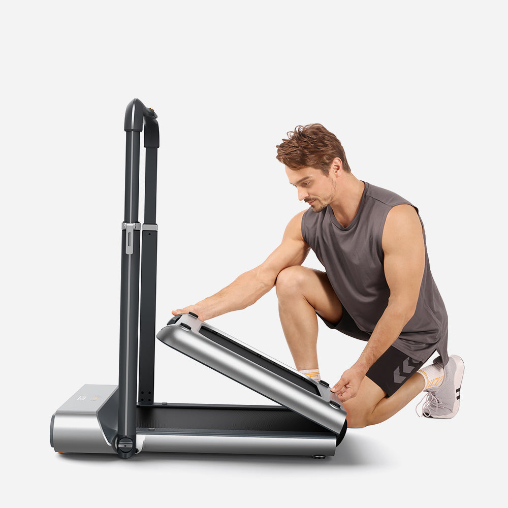 Man using the WalkingPad R1 Pro 2IN1 Foldable Treadmill, adjusting its foldable design for storage.