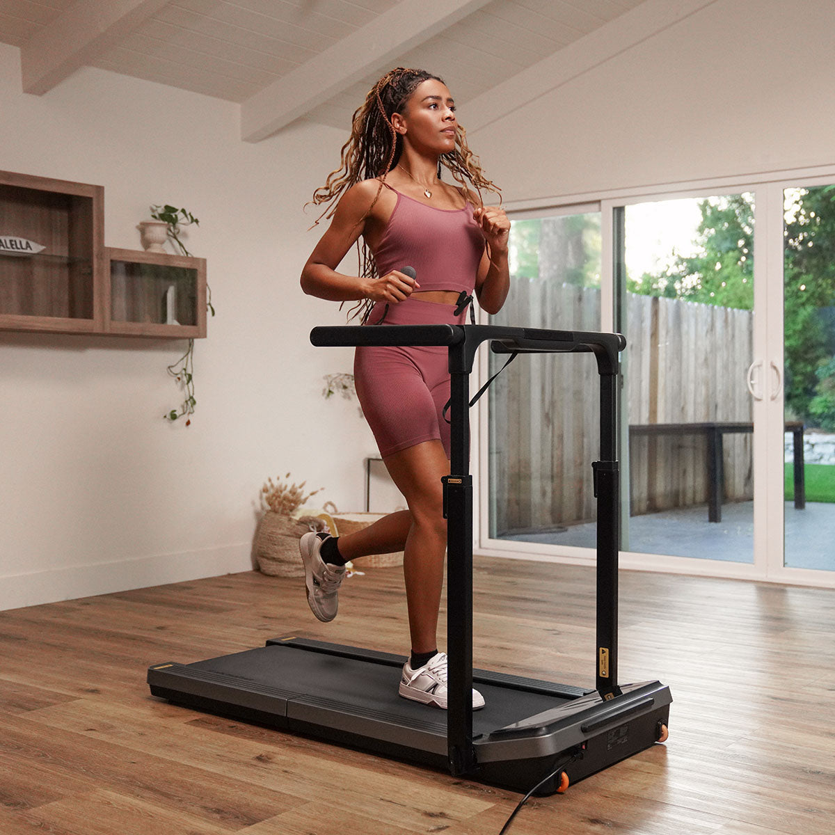 A woman jogging on the WalkingPad Z3 Hybrid+ Foldable Treadmill in a modern home setting.