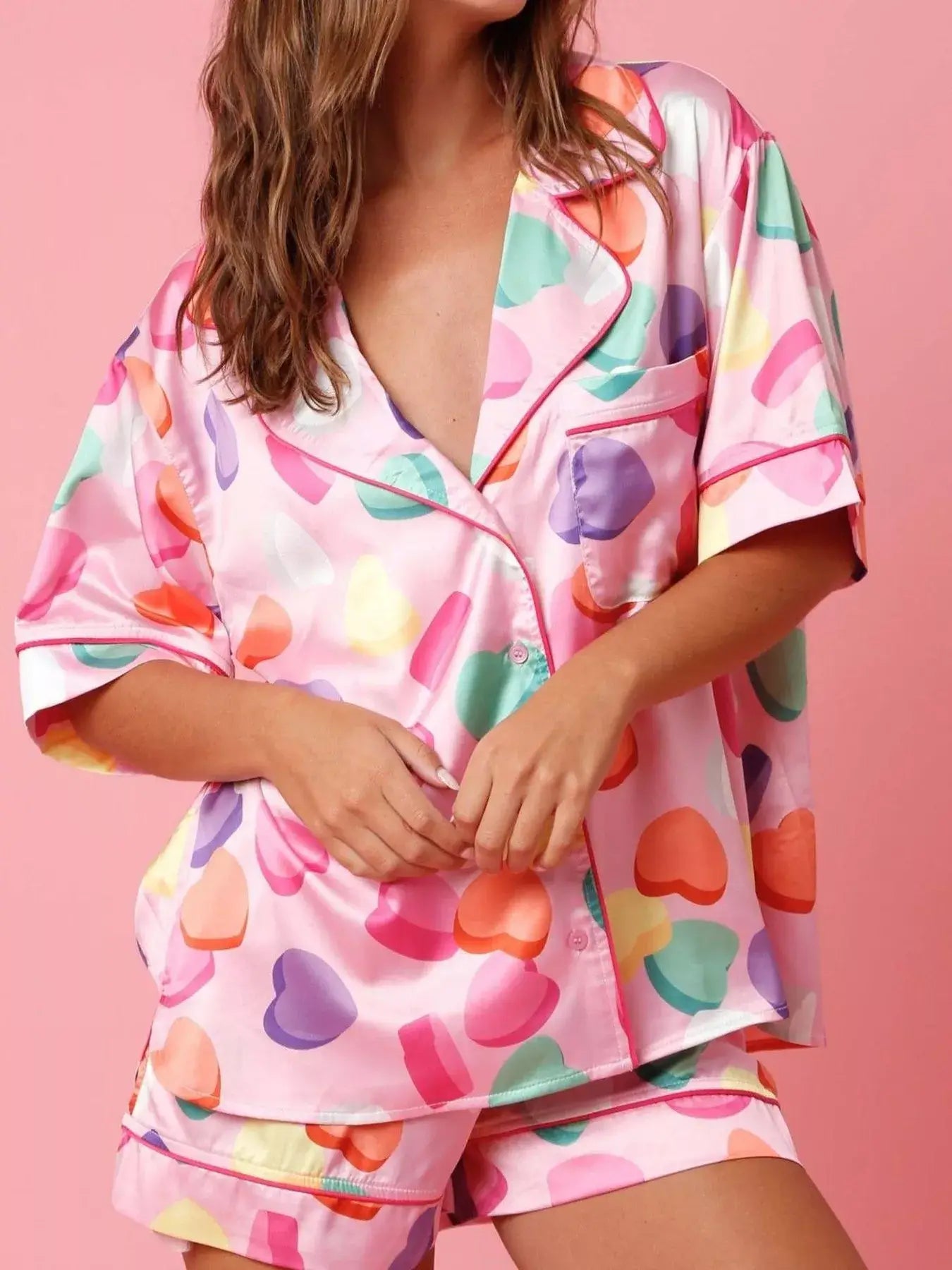 Button Up Half Sleeve Shirt and Shorts Lounge Set displayed with colorful heart patterns and vibrant pink background.