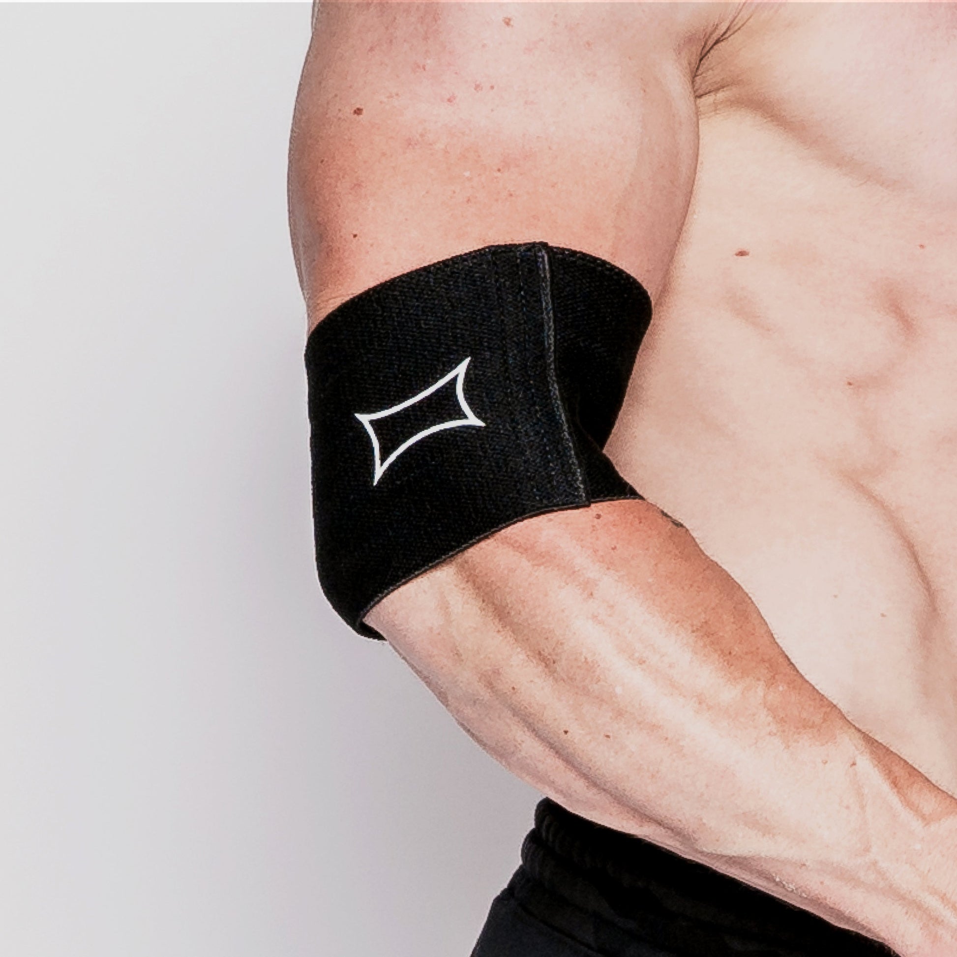 Close-up of a Biggie Compression Cuff worn on a muscular arm, providing support for elbow pain and maximizing coverage.