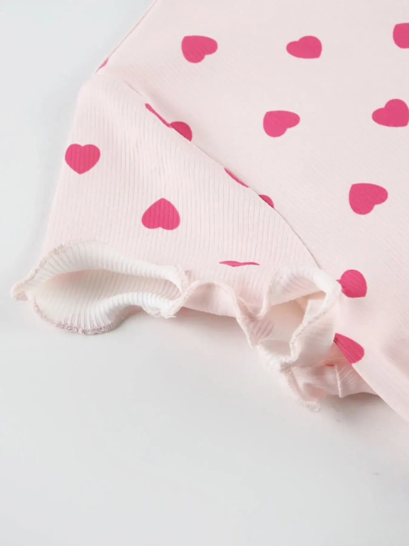 Close-up of sleeve detailing on Heart Print Top and Shorts Loungewear Set with pink heart patterns.