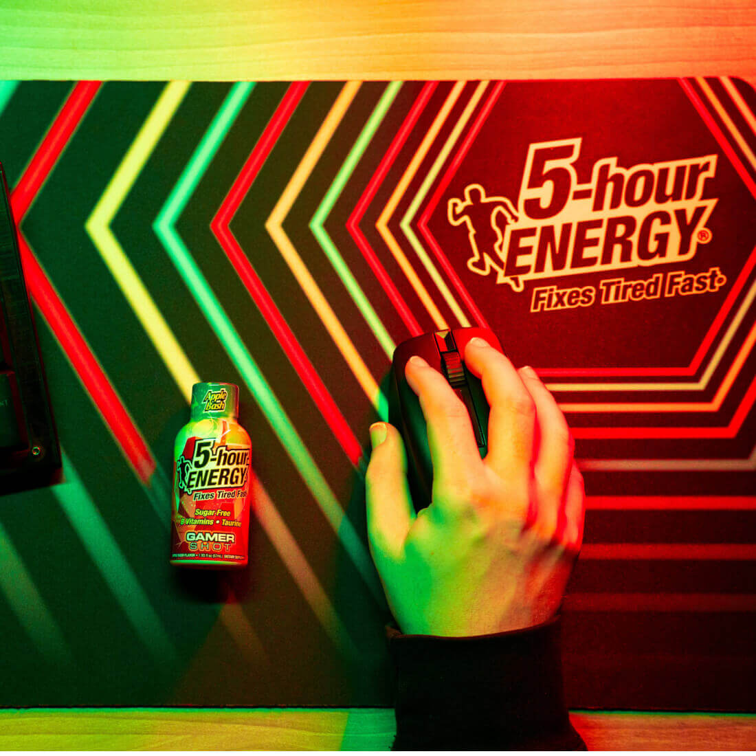 Pineapple Charge Extra Strength 5-hour ENERGY Shots next to a gaming mouse on an energizing mouse pad.