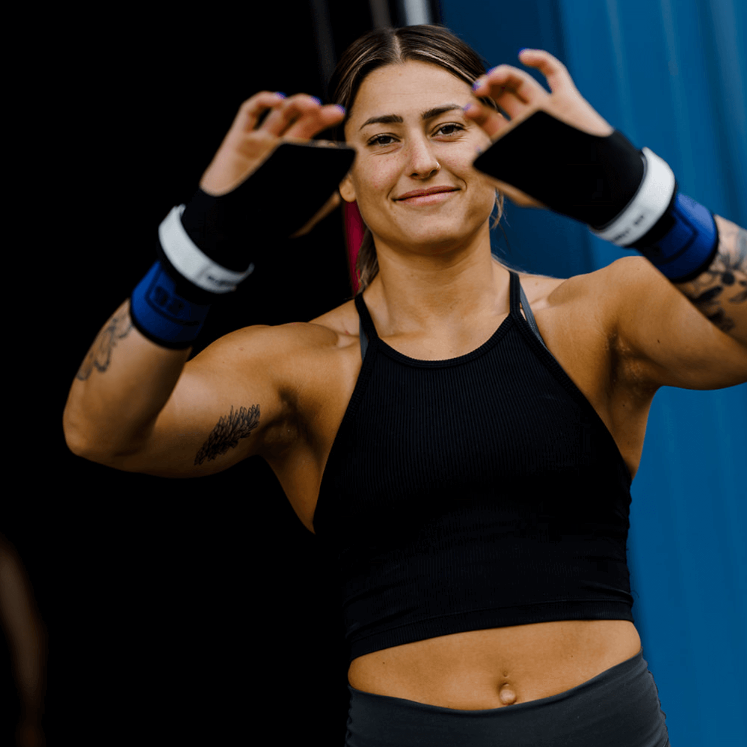 Woman showcasing Isocomp Gymnastic Hand Grips, highlighting versatility and grip technology.