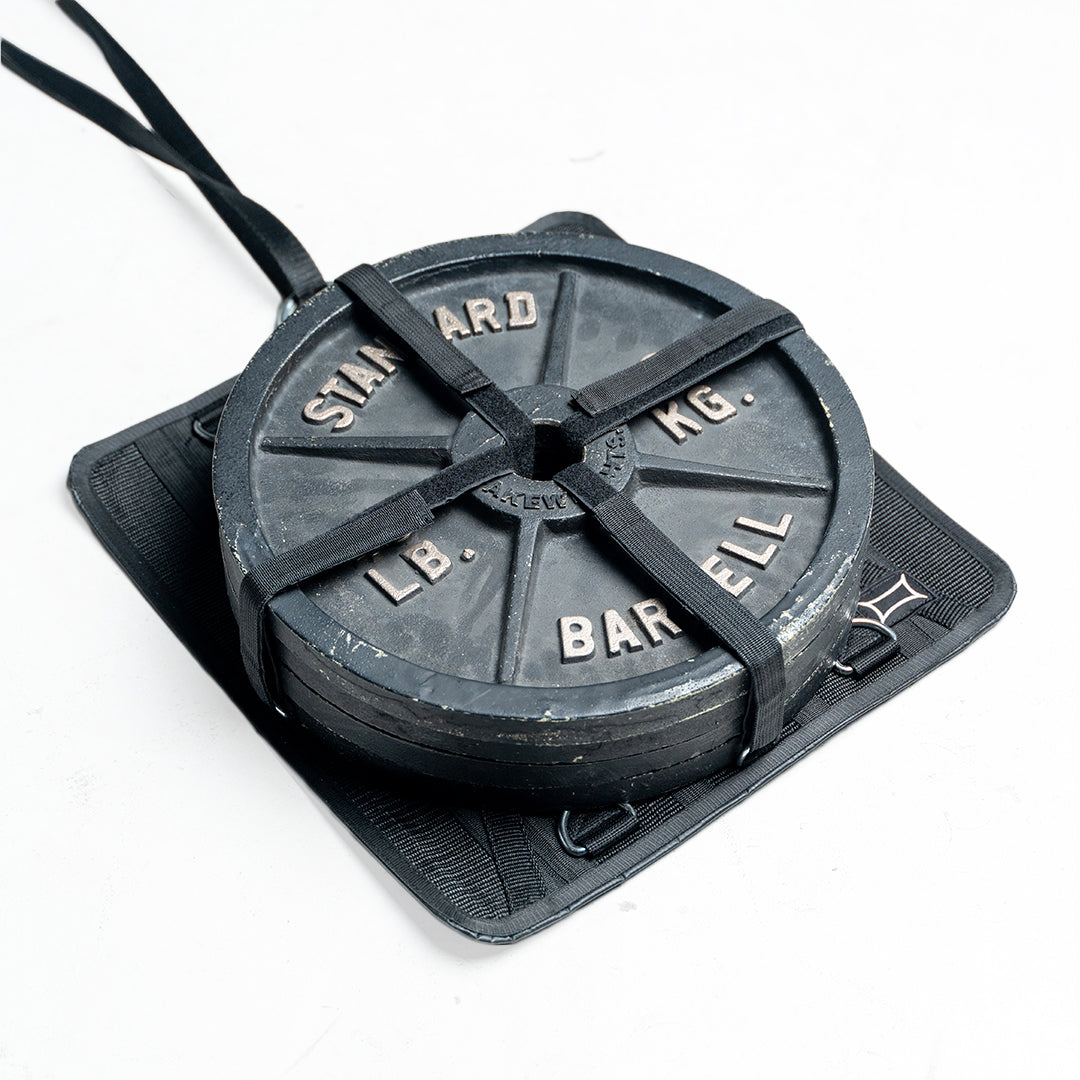 Stealth Sled attachment with iron weight plate for versatile pulling training on the go.