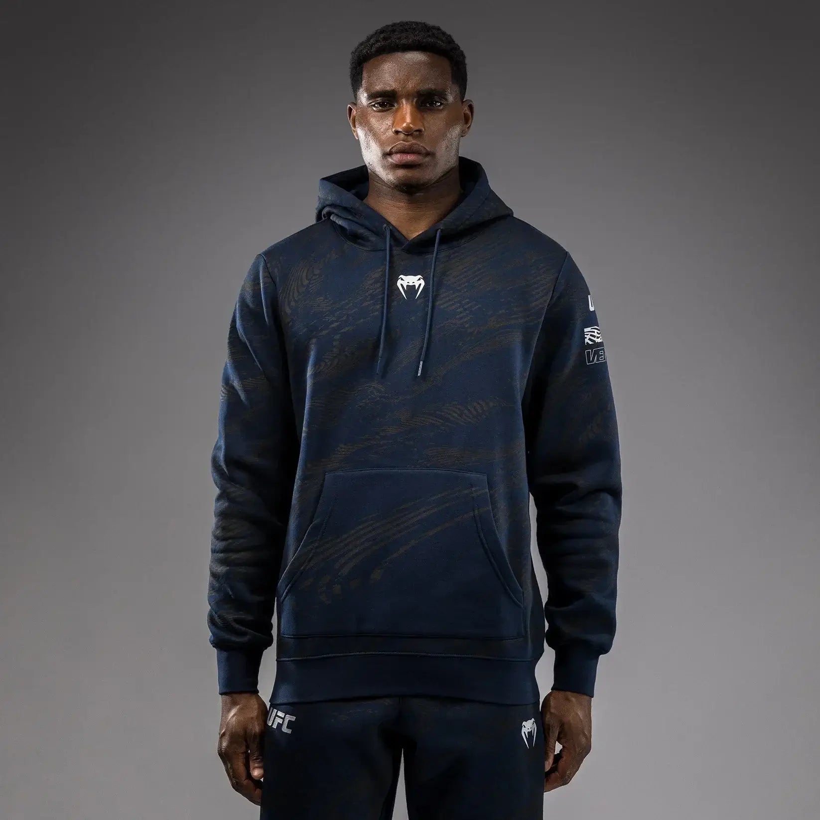 UFC Fusion Fight Week Pullover Hoodie modeled by a man, showcasing its modern design and performance fabric.