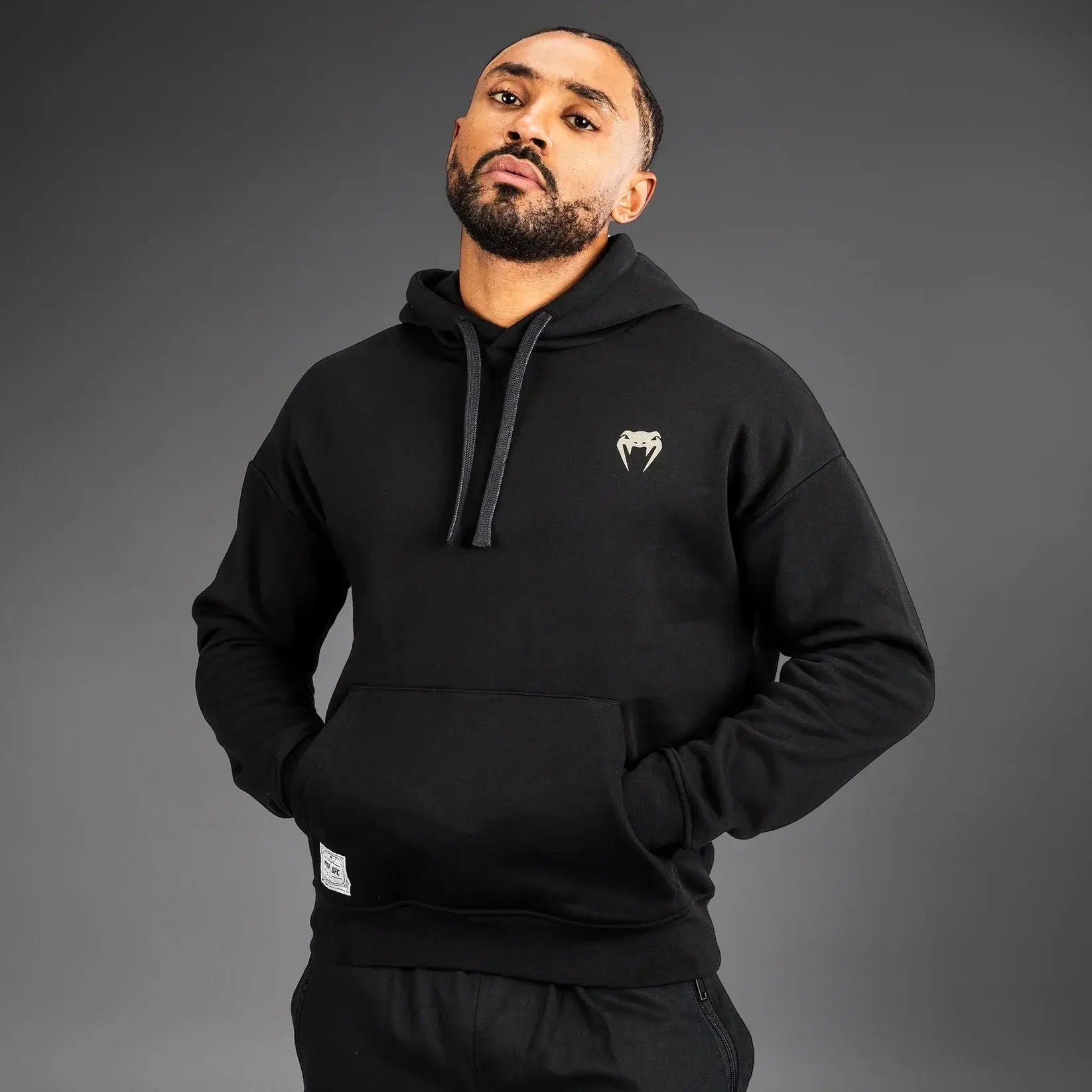 UFC Ulti-Man Competition Hoodie worn by a model, showcasing the iconic Ulti-Man logo in a stylish black design.