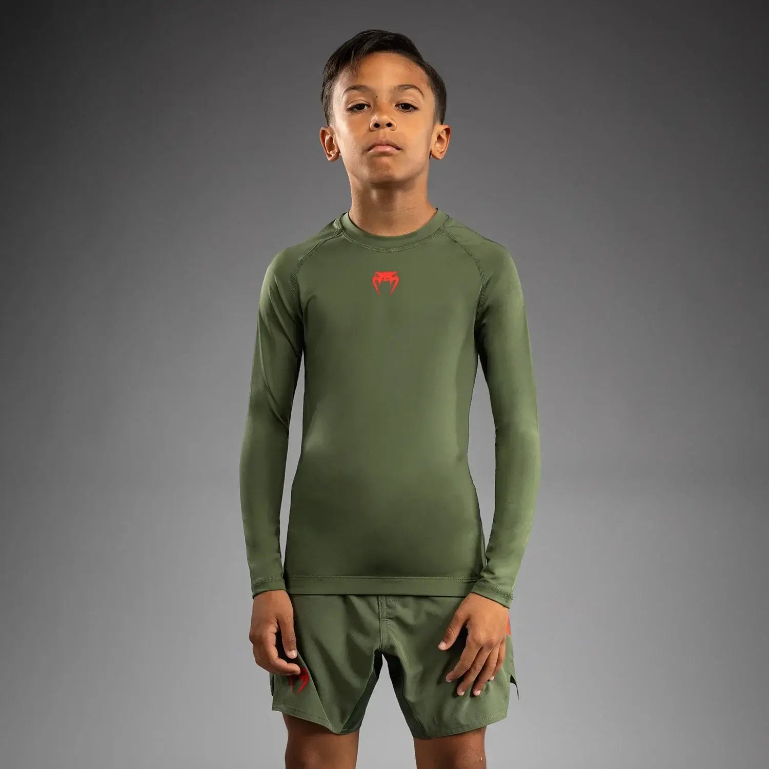 Venum Contender Kids Rash Guard - Long Sleeve worn by a young athlete in green, showcasing comfort and flexibility.