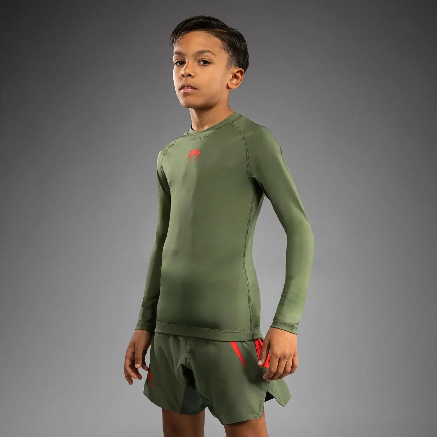 Venum Contender Kids Rash Guard - Long Sleeve modeled by a young athlete in a green long sleeve shirt.