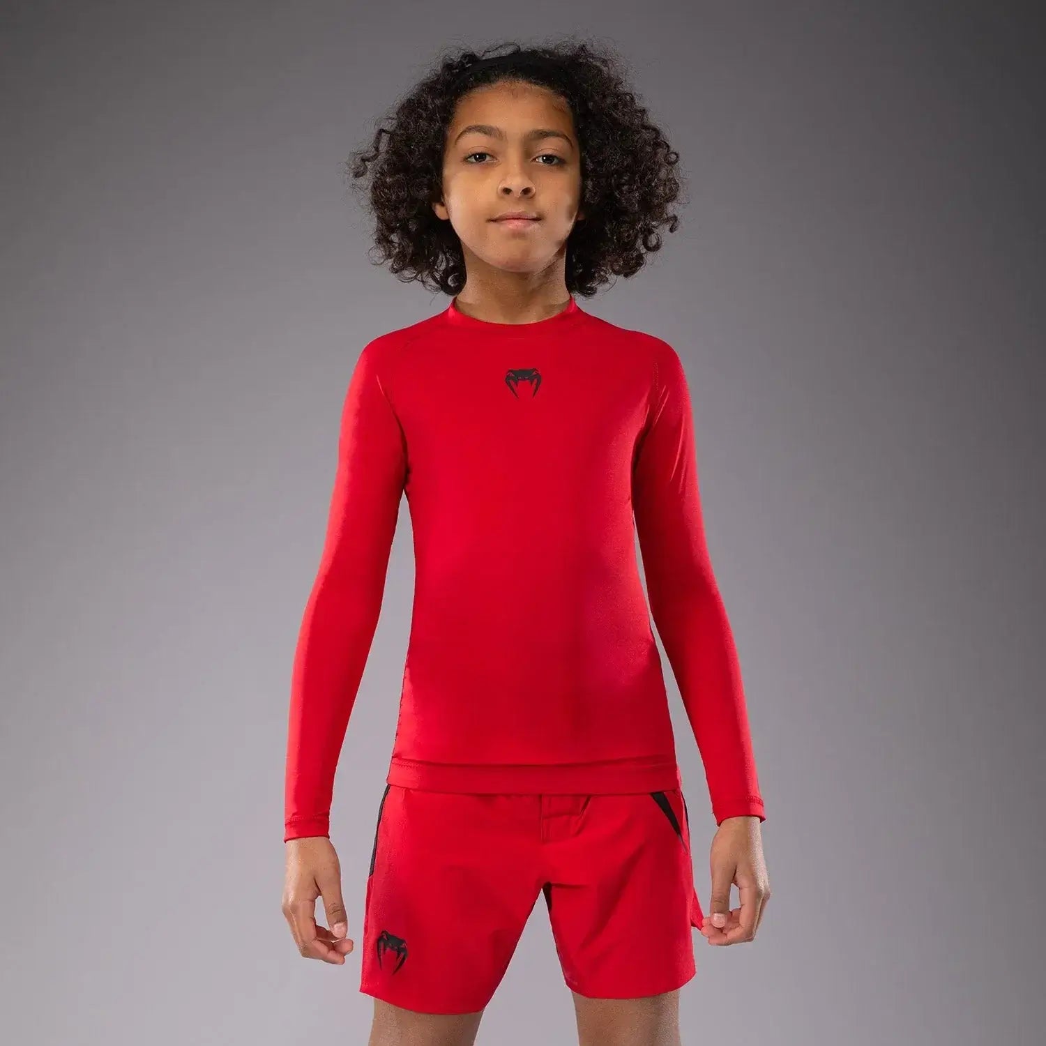 Venum Contender Kids Rash Guard - Long Sleeve worn by a child in red, showcasing comfort and style for young athletes.